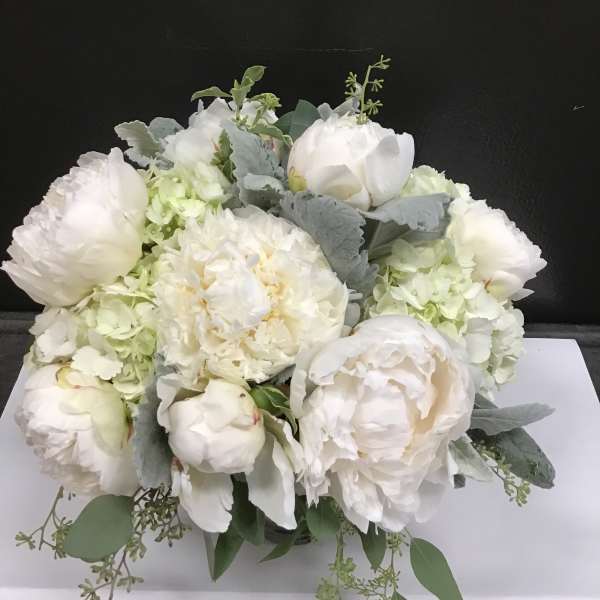 White peonies and hydrangeas arranged in a low bouquet