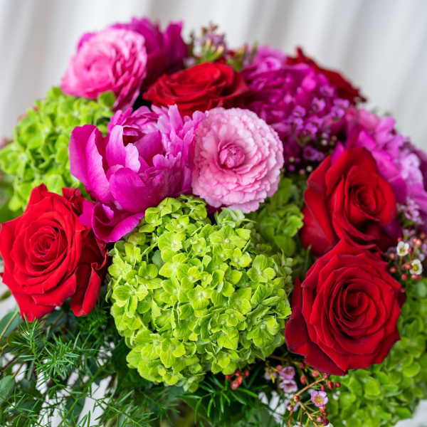 Bouquet of red roses, pink blooms, and green hydrangeas