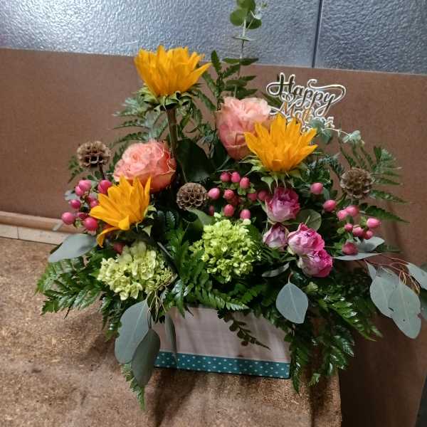 Mixed bouquet in a box with pink roses and yellow blooms