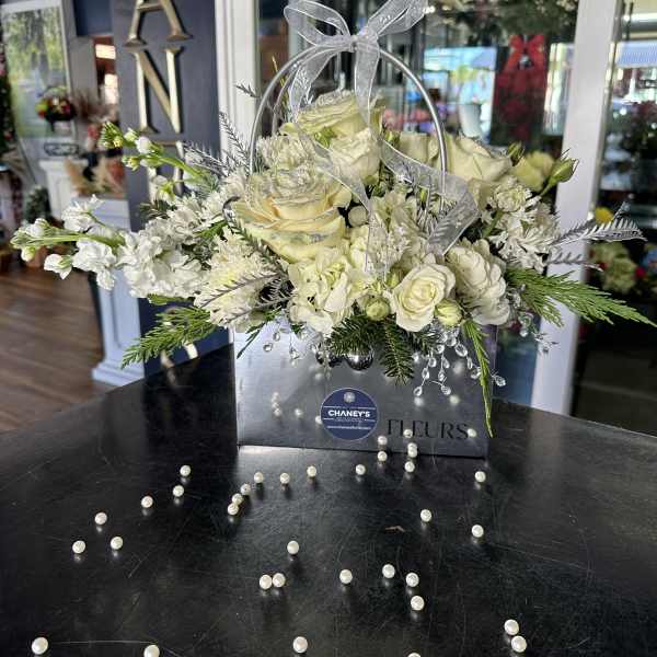 White rose arrangement in a silver gift bag with a sheer bow