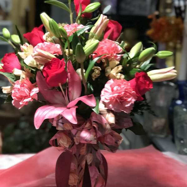 Bouquet of red roses, pink lilies, and carnations in a vase
