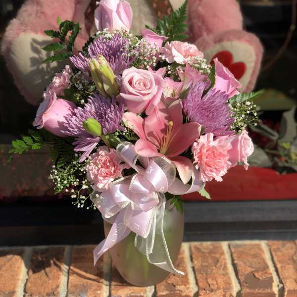 Pink mixed bouquet in a vase with a ribbon bow