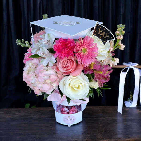 Pink and white graduation bouquet in a cap-shaped box with a "YAY" topper