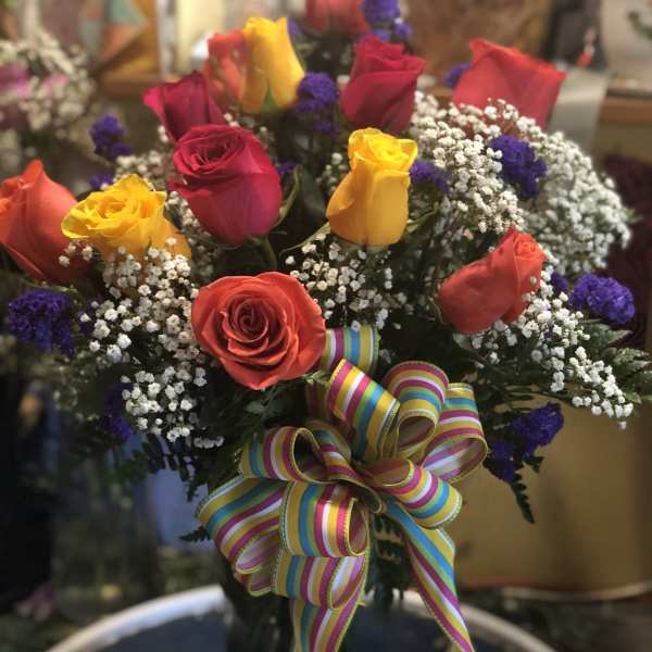 Bouquet of multicolored roses with baby's breath and a striped ribbon bow