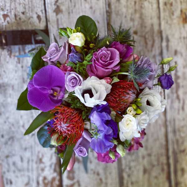 Bouquet of purple, pink, and white flowers with orchids and roses