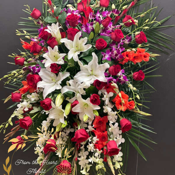 Large standing spray of red roses, white lilies, and purple orchids