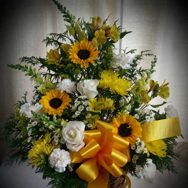 Basket arrangement of yellow sunflowers and white roses with a large yellow bow