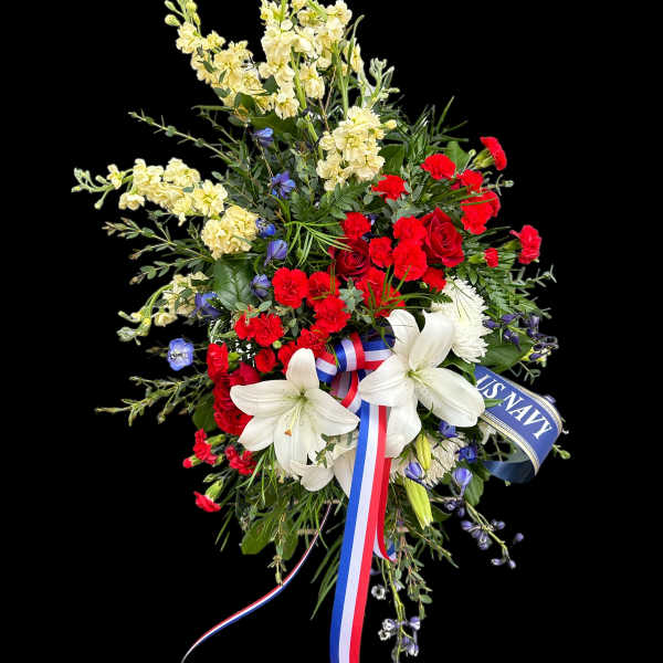 Red and white floral spray with ribbon and navy tribute sash