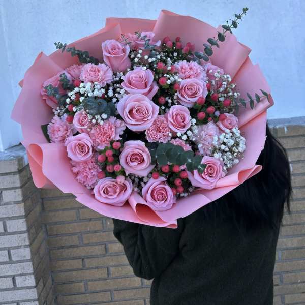 Large bouquet of pink roses and carnations wrapped in pink paper