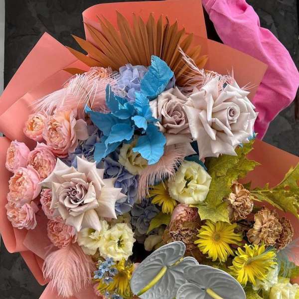 Large mixed bouquet with pastel roses and yellow daisies wrapped in pink paper