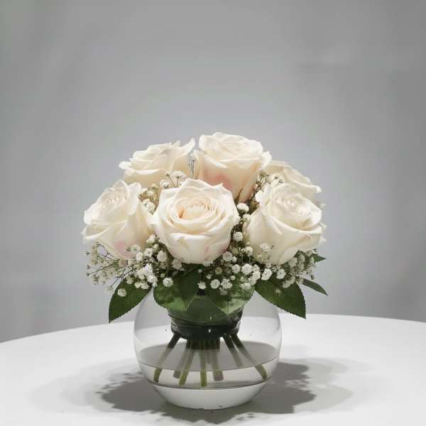 White roses arranged in a clear glass vase