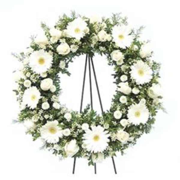 White floral funeral wreath on a stand