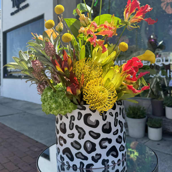 Bright tropical flower arrangement in a patterned box