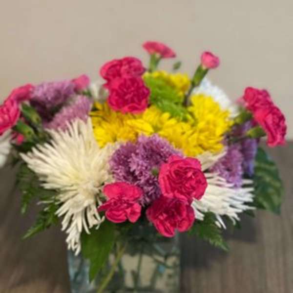 Colorful mixed bouquet in a square glass vase