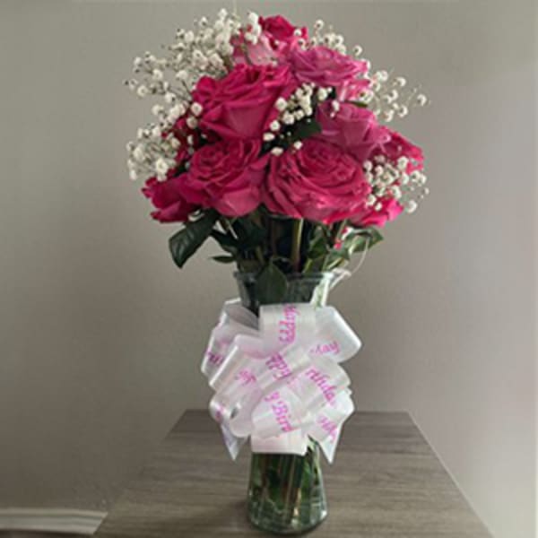Bouquet of pink roses with baby's breath in a glass vase