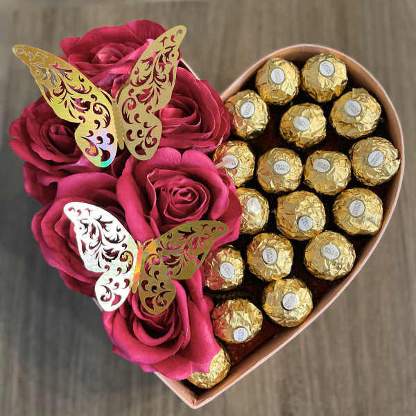Heart-shaped box with pink roses and gold-wrapped chocolates