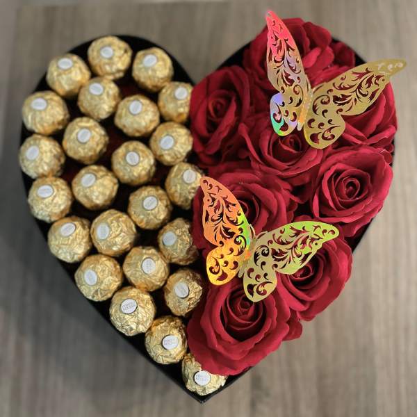 Heart-shaped box with red roses and gold-wrapped chocolates