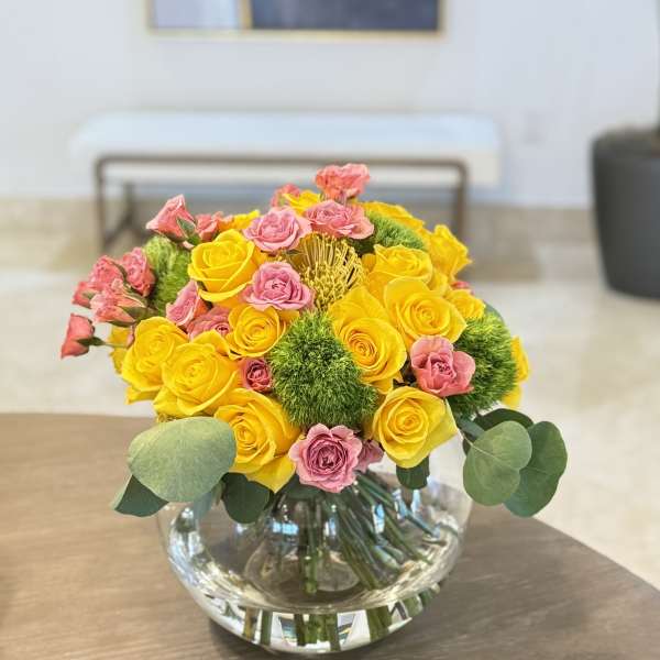 Yellow and pink rose bouquet in a clear glass vase