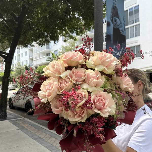 Large bouquet of pale pink roses with burgundy wrap