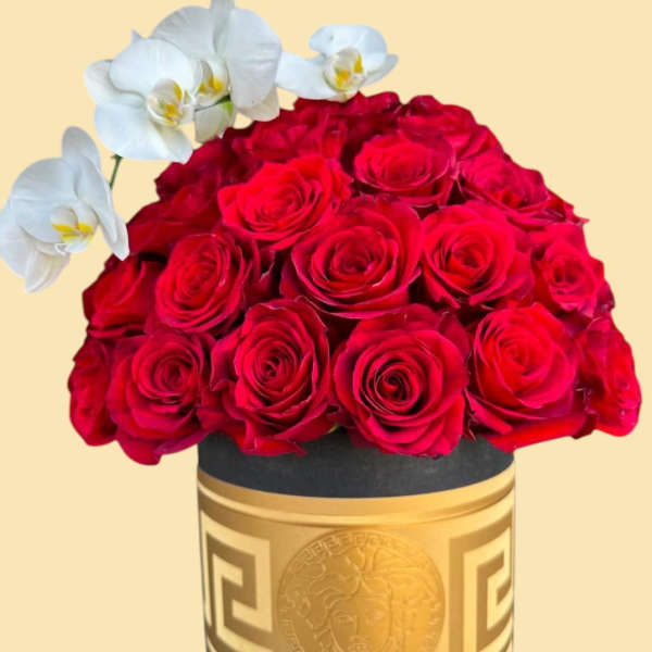 Red roses arranged in a gold round box with white orchids