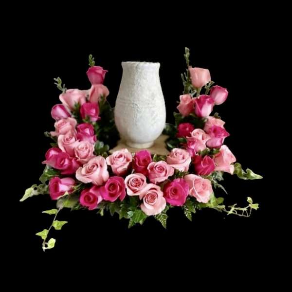 Pink and blush roses arranged around a white vase