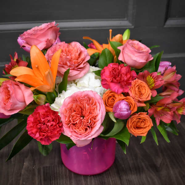 Pink and orange mixed bouquet in a magenta vase