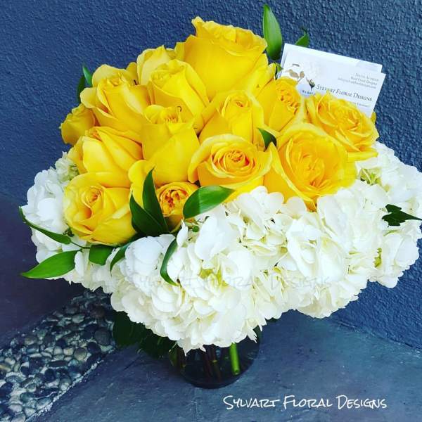 Yellow roses and white hydrangeas in a vase