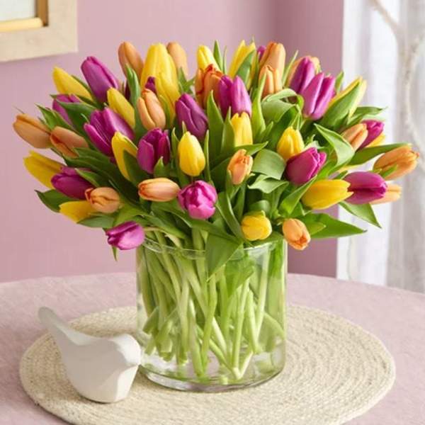 Bouquet of multicolored tulips in a clear glass vase