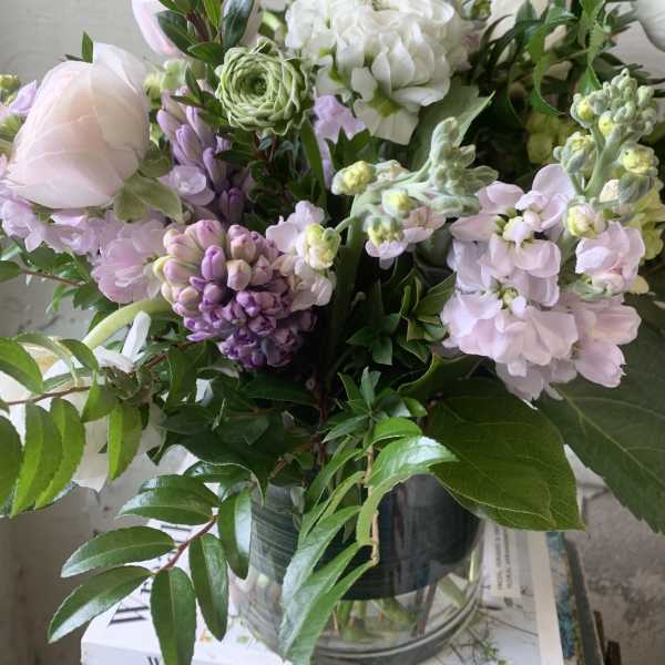 Pastel bouquet of white, pink, and purple flowers in a glass vase