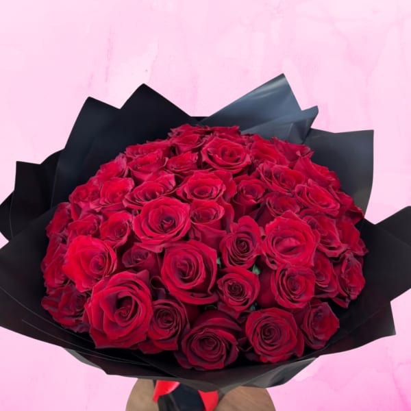 Bouquet of red roses wrapped in black paper