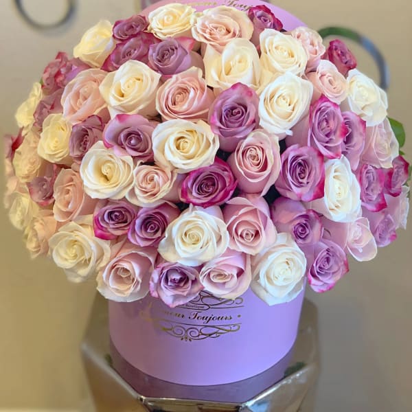 Bouquet of pink, white, and lavender roses in a lavender hat box