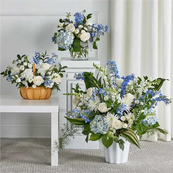 Blue and white floral arrangements in white and wooden containers