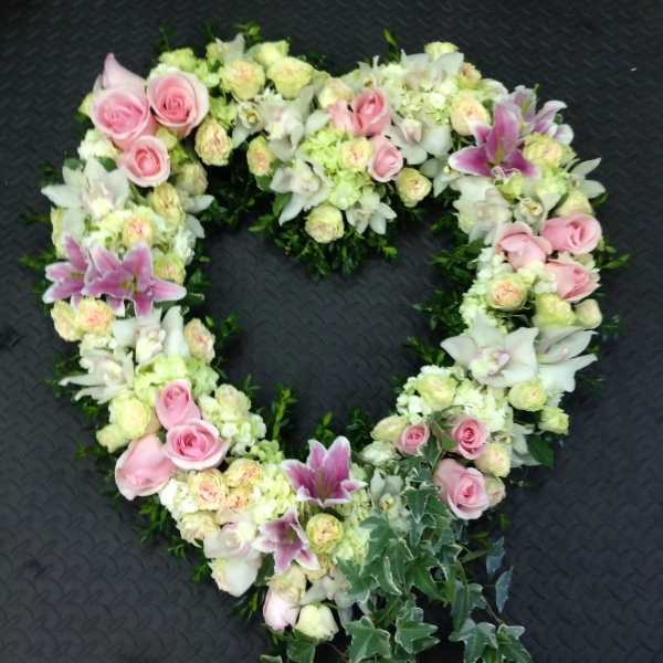 Heart-shaped floral wreath with pink roses and white lilies