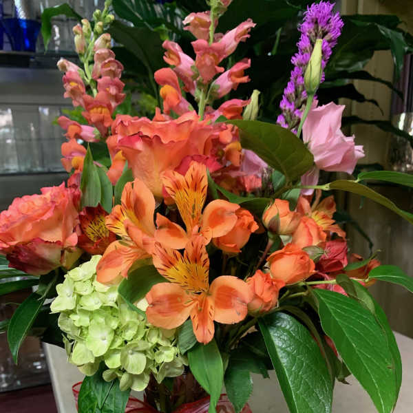 Colorful mixed bouquet in a glass vase with a ribbon bow