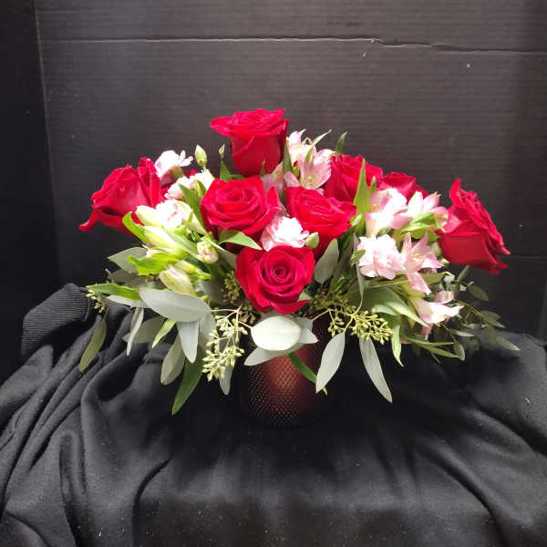 Red roses and pink alstroemeria arranged in a low vase