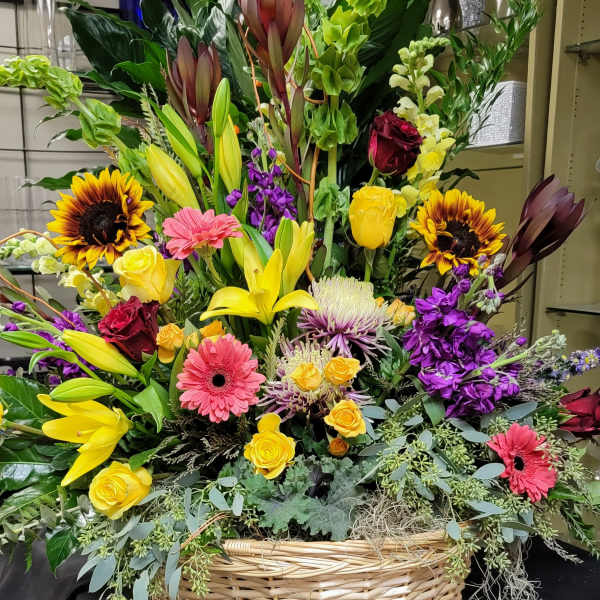 Large mixed flower basket with lilies, roses, gerberas, and sunflowers