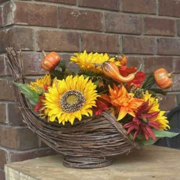 Autumn bouquet of sunflowers and orange flowers in a woven basket