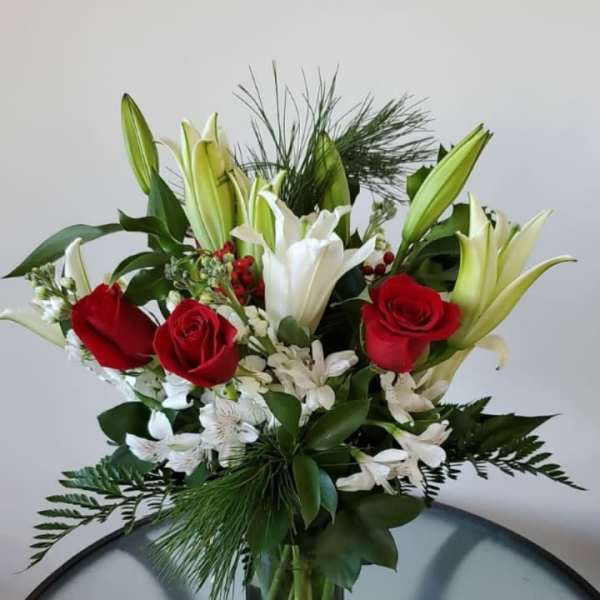Bouquet of red roses and white lilies in a gold vase