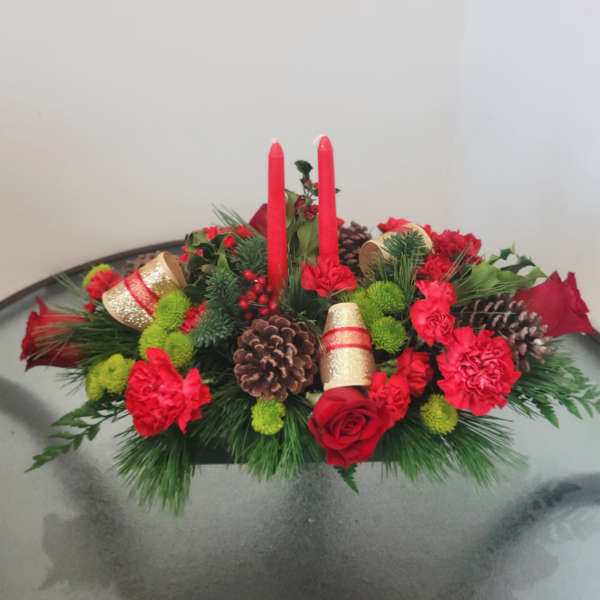 Red floral centerpiece with candles, pinecones, and ribbon accents