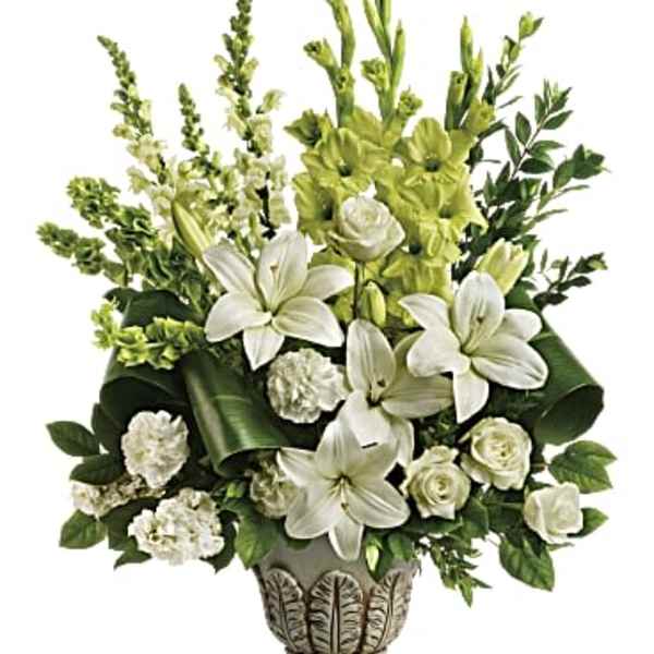 White lilies and roses arranged in a decorative urn with green accents