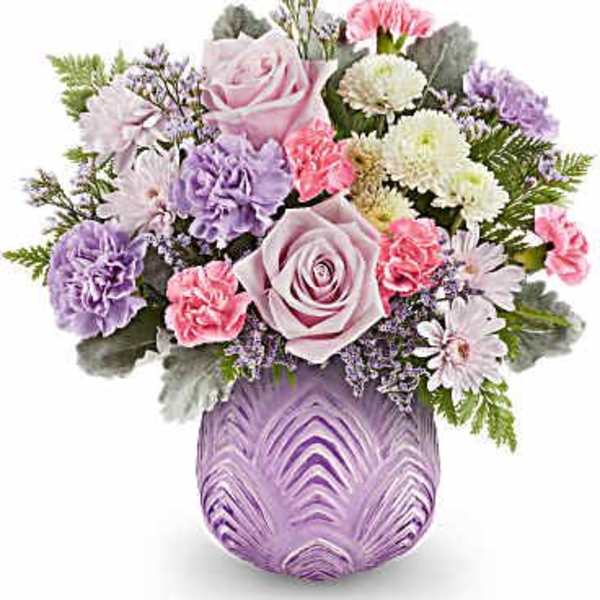 Lavender and pink floral arrangement in a purple glass vase