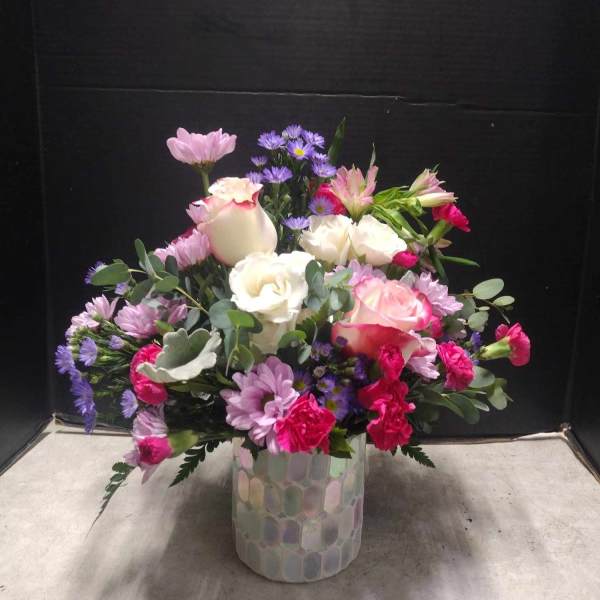 Mixed pink, white, and purple bouquet in a patterned glass vase