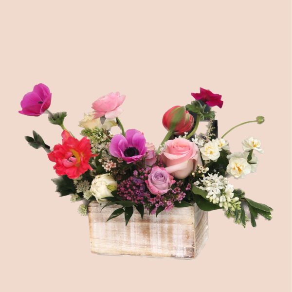 Mixed bouquet in a rustic wooden box with pink, red, white, and purple blooms