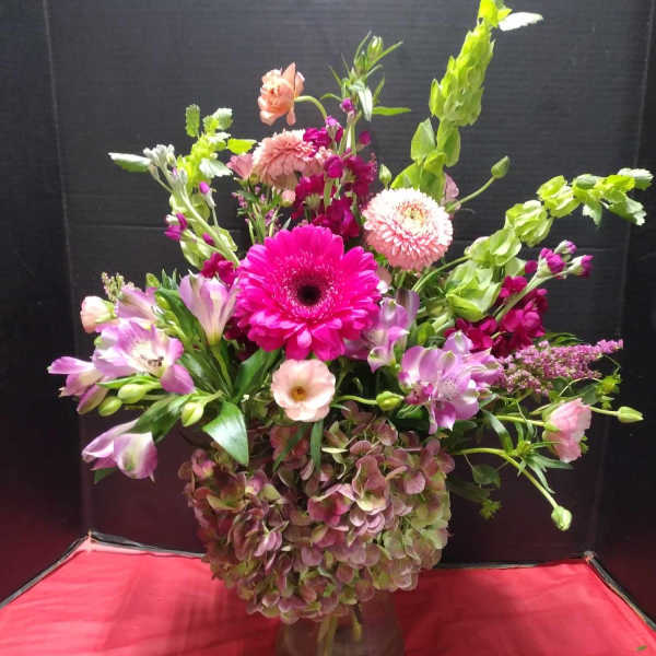 Mixed pink and green flower arrangement in a glass vase