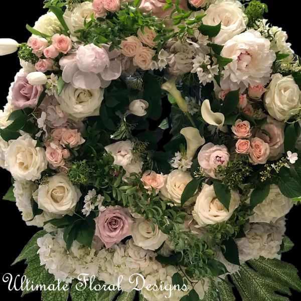 Large floral wreath of white and blush roses with greenery