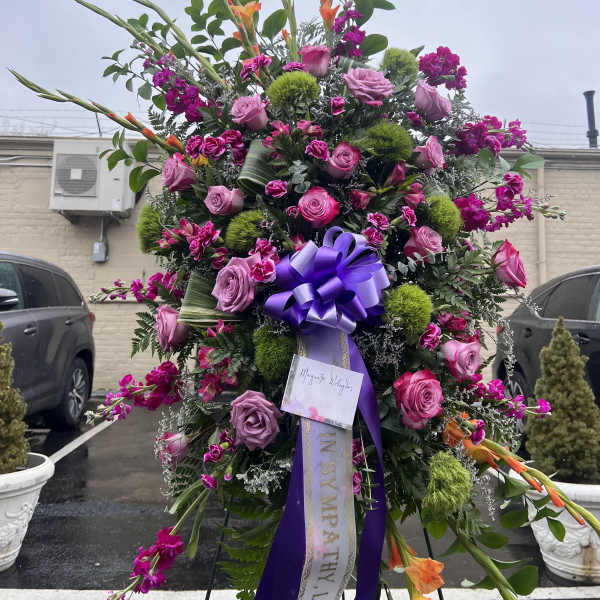 Large standing floral spray with pink roses and purple ribbon