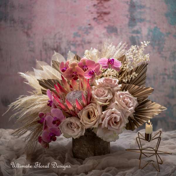 Bouquet of blush roses and pink orchids in a rustic vase