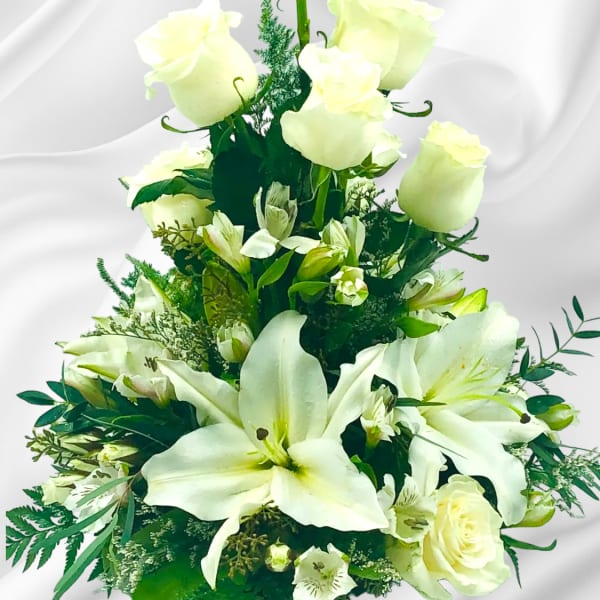 White roses and lilies in a tiered floral arrangement