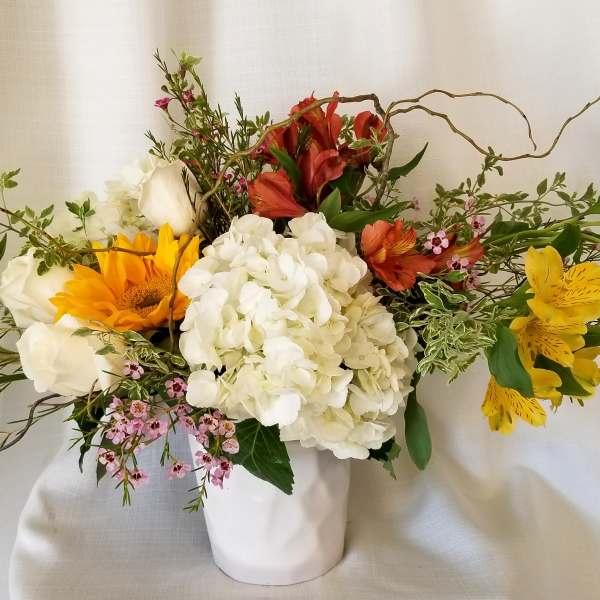 Mixed bouquet in a white vase with white, yellow, and red flowers