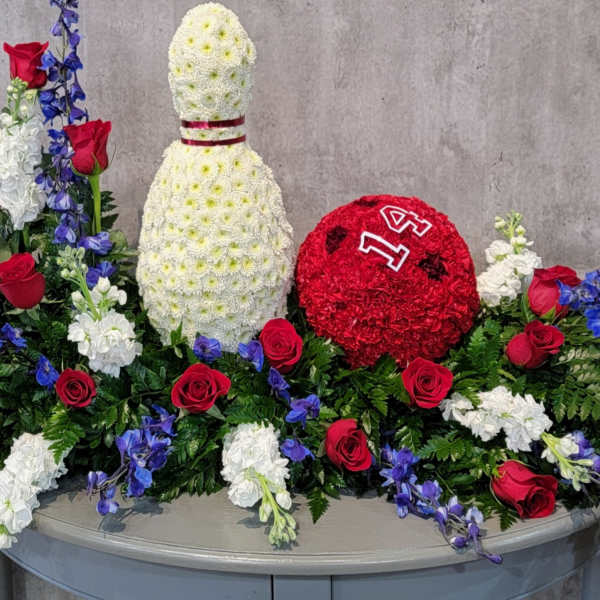 Floral display with a white bottle shape and a red round floral piece
